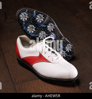 Chaussures de golf moderne sur un parquet en bois blanc et rouge cuir avec semelle en plastique et de pointes Banque D'Images
