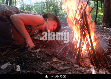 Expert en milieu sauvage femme montre comment allumer un feu de camp. Banque D'Images