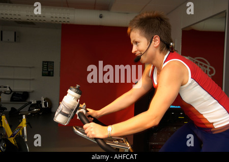 Entraîneur féminin à la tête d'un groupe vélo de spinning in a gym Banque D'Images