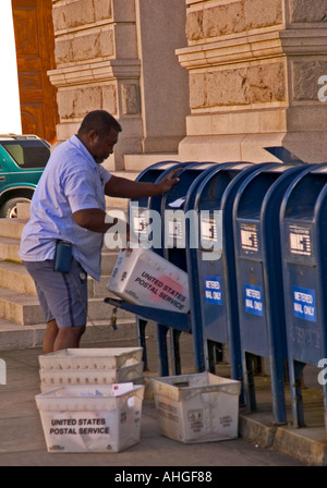 Afro-américain travailleur des services postaux des États-Unis collectant le courrier dans les boîtes de dépôt dans le centre-ville de Charleston, Caroline du Sud, États-Unis. Banque D'Images