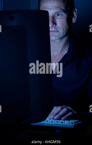L'homme travaillant tard dans un ordinateur Banque D'Images