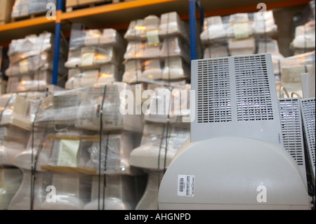 Moniteur CRT ordinateur reconditionné dans un entrepôt contenant des palettes de vieux ordinateurs mis au rebut pour recyclage Banque D'Images