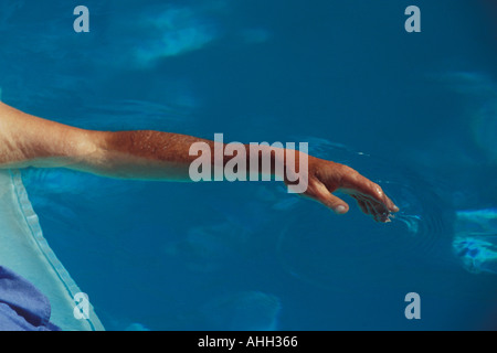 L'homme sur matelas d'air flottant dans une piscine extérieure et de la main Banque D'Images