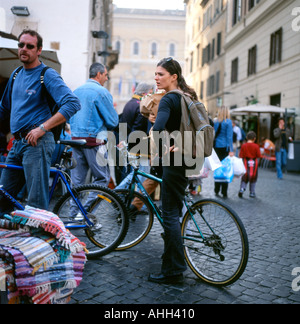 Un couple fait du shopping sur des vélos dans une rue pavée à proximité Campo de Fiori marché Rome en Italie Europe UE KATHY DEWITT Banque D'Images