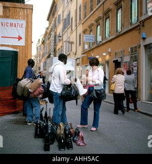 Un touriste américain de l'achat d'un sac à main de concepteur d'un vendeur de rue d'Afrique à Rome Italie KATHY DEWITT Banque D'Images