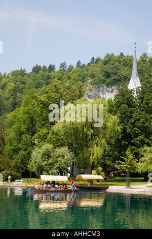 Le lac de Bled en été avec un mobilier traditionnel en pletnja aviron bateaux amarrés sur la rive Bled Slovénie Union Européenne Banque D'Images