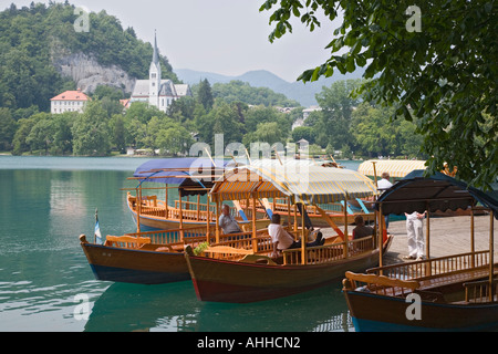 Le lac de Bled en été avec un mobilier traditionnel en pletnja barques amarrés sur jetty Banque D'Images