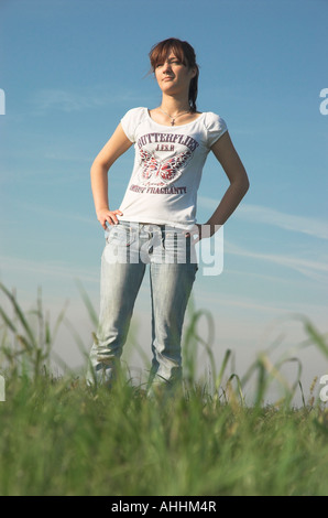 Young woman standing in field à la recherche à distance Banque D'Images