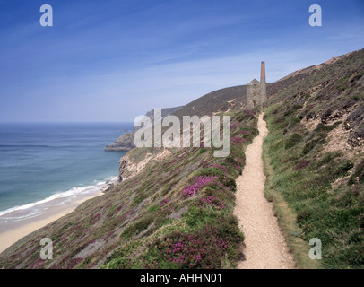 Paysage et sentier de la côte nord de Cornwall, en haut de la falaise, désuétude de l'étain Bâtiment historique de la mine et cheminée dans un site classé au patrimoine mondial Journée ensoleillée Angleterre Royaume-Uni Banque D'Images