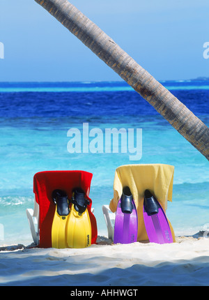 Chaises de plage et serviettes sur sable à l'ombre de palmier Banque D'Images