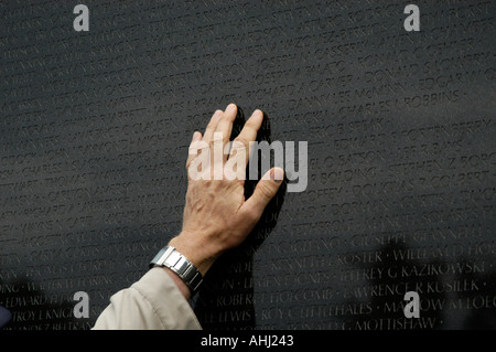 Ancien combattant de toucher main sur le noms des soldats morts au Vietnam Veterans Memorial, Washington DC, USA Banque D'Images