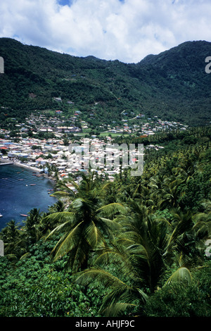 Vue sur les palmiers dans la baie de Soufriere avec des bateaux et la ville nichée dans une vallée verdoyante et luxuriante. Banque D'Images