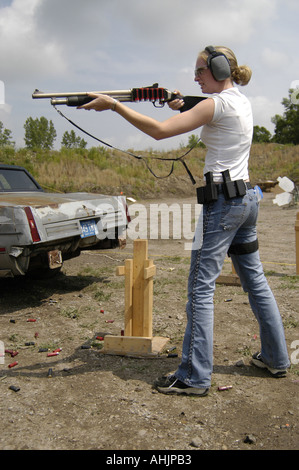 Caucase teen girl wearing étui, protection des yeux et oreilles, se prépare à tirer au fusil de tir Banque D'Images