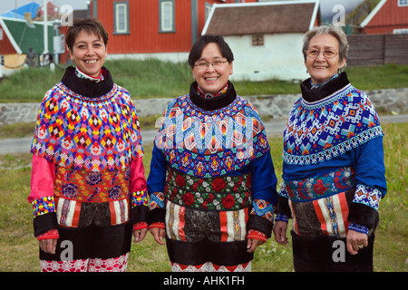 Trois belles dames en costume traditionnel de conception complexes pose devant l'appareil photo à Sisimiut sur la côte ouest du Groenland Banque D'Images