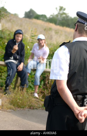 Un jeune garçon habillé en fille et chavs de déconner et être interrogé par un agent de police Banque D'Images