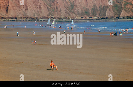 Un homme assis dans une chaise longue sur une plage déserte à Filey dans Yorkshire du Nord Banque D'Images