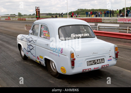 Ford Anglia populaires fortement modifiées laissant à startline drag race Banque D'Images