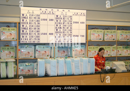 Femme de vente au comptoir d'une boutique de la soie à Shanghai Banque D'Images