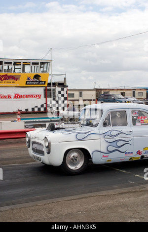 Ford Anglia populaires fortement modifiées laissant à startline drag race Banque D'Images