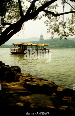 L'Hangzhou West Lake avec bateau de tourisme le long de la côte de l'île petite mer avec pagode à distance Banque D'Images
