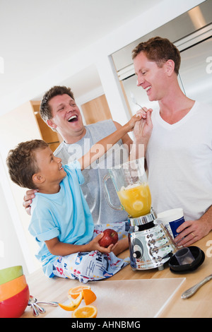 Couple Gay, faisant des smoothies avec leur fils Banque D'Images