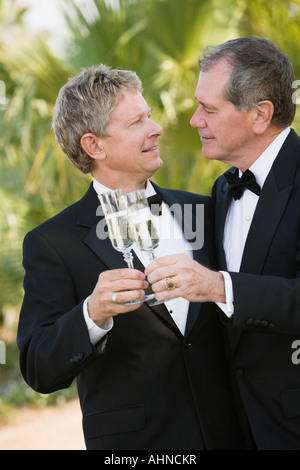 Young gay couple toasting each other with champagne Banque D'Images