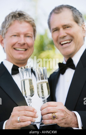 Young gay couple toasting each other with champagne Banque D'Images