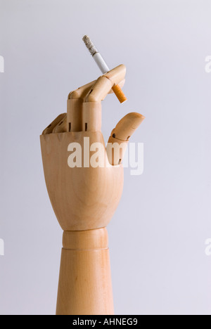 Main en bois avec une cigarette allumée Banque D'Images