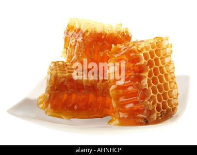 Cire d'abeille jaune détail cellulaire tranche sur plaque blanche Banque D'Images