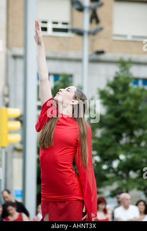 Danseuse blonde avec des vêtements rouges dans street festival de danse contemporaine et théâtre, danse en paysages urbains. Saragosse, Espagne Banque D'Images