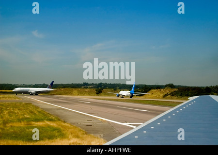 Grand angle horizontal de plusieurs gros avions commerciaux dans une file d'attente d'instructions pour le décollage de la piste. Banque D'Images