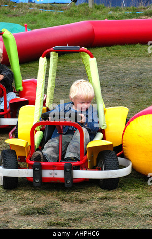 Jeune garçon au volant d'un go-kart dans une école fun day. Banque D'Images