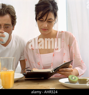 Couple avec journal au petit déjeuner Banque D'Images