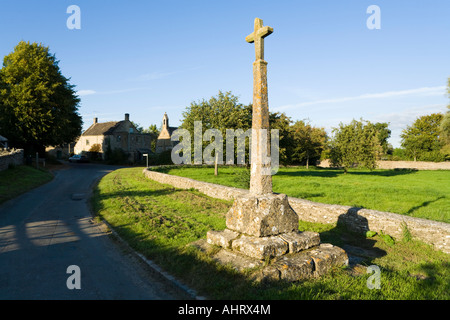 La lumière du soleil du soir qui tombe sur le 14e siècle calvaire dans le village de Cotswold Condicote, Gloucestershire Banque D'Images