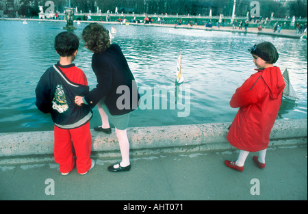 Paris France, Parcs jeunes enfants français jouant avec des voiliers à jouets sur l'étang dans les jardins du Luxembourg, à l'extérieur de la fontaine dans le parc public Banque D'Images