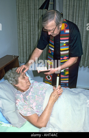 Prêtre catholique administre les derniers sacrements à 74 ans femme Banque D'Images