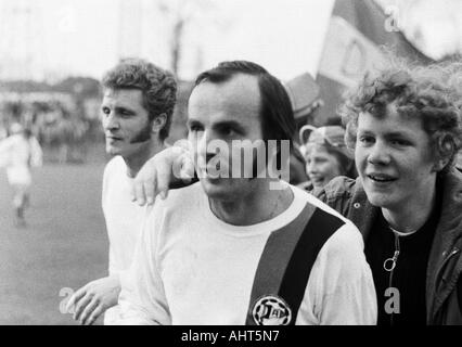 Football, Bundesliga, 1970/1971, le FC Schalke 04 contre Arminia Bielefeld 0:1 Stade, Glueckaufkampfbahn à Gelsenkirchen, Bielefeld joueurs Waldemar Slomiany (à gauche) et Gerd Roggensack (à venir) célébrer ensemble avec les fans de football Bielefeld gagner de thi Banque D'Images