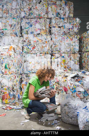 Femme tri par le biais de documents à une usine de recyclage. Banque D'Images
