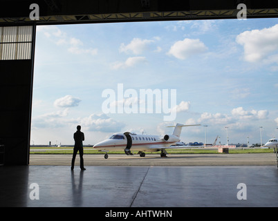 Dans le hangar à la recherche de technicien en jet privé sur le tarmac. Banque D'Images