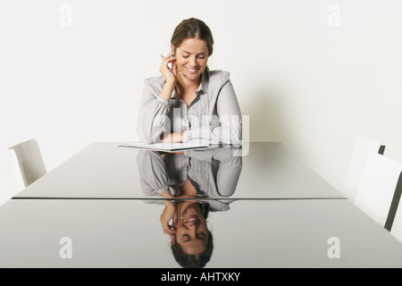 Jeune femme d'affaires au bureau avec des réflexions. Banque D'Images