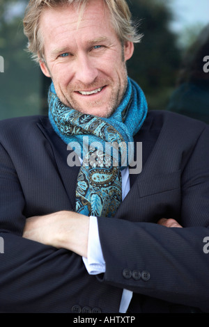 Businessman wearing scarf extravagantes appuyé contre la fenêtre. Banque D'Images