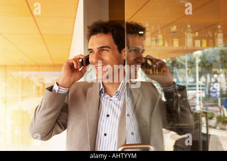 L'homme parle sur son téléphone cellulaire dans une porte. Banque D'Images