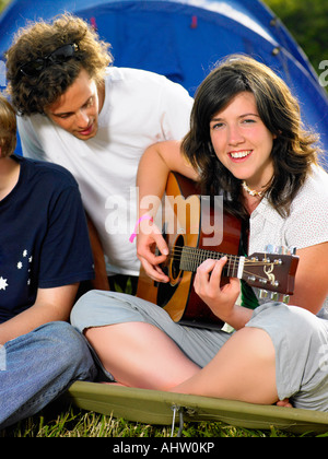 Girl playing guitare tout homme regarde au-dessus Banque D'Images