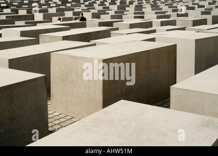 Vue horizontale de plusieurs touristes marchant à travers le mémorial de l'Holocauste, aka Monument aux Juifs assassinés, lors d'une journée ensoleillée. Banque D'Images
