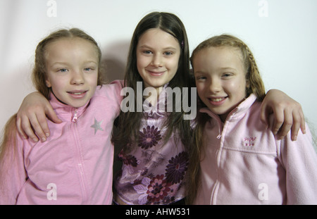 Deux sœurs jumelles et d'autre d'un ami hugging posing and smiling Banque D'Images