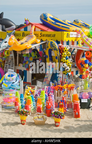 Vue verticale de jouets en plastique de couleurs vives et de pneumatiques pour la plage, en vente à plage de Weymouth. Banque D'Images