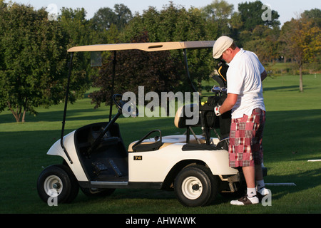 Homme de golf américain avec des clubs de golf dans le sac et une voiturette de golf sur le terrain de golf herbe verte images de fond images aux États-Unis horizontal haute résolution Banque D'Images