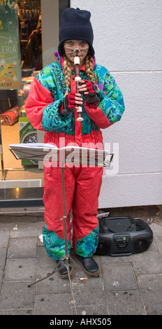 Jeune femme enfant jouant flute musicon la rue pendant la période de Noël à Aix-la-Chapelle, Allemagne Banque D'Images