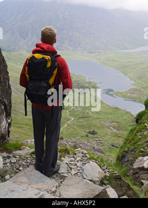 Jeune homme seul se tenant à la recherche jusqu'à Llyn Idwal dans le MCG de Devil's Kitchen sentier dans le parc national de Snowdonia au nord du Pays de Galles Royaume-uni Grande-Bretagne Banque D'Images