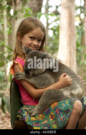 Jeune fille enfant tenant un Koala dans Lone Pine Koala Sanctuary wildlife reserve Brisbane Queensland QLD Australie zoo OD Banque D'Images
